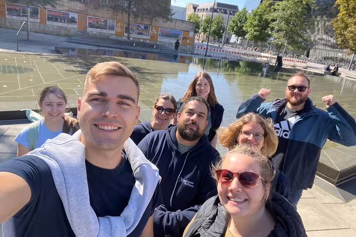 Group selfie by Freiburg Platz der Alten Synagoge fountain on a self-guided scavenger hunt and sights tour
