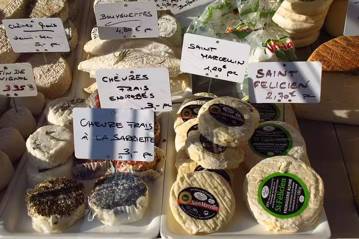 Assorted French cheeses displayed at a market stall in Old Town Nice, highlighting gourmet flavors on the food tour.