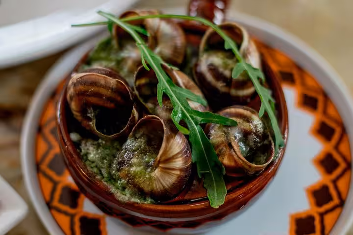 Traditional French escargot with garlic and herbs in Le Marais, a must-try on our Paris food tour.