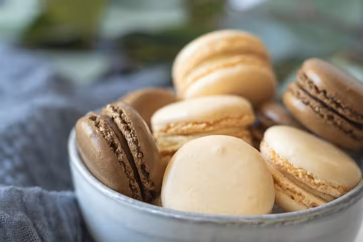 A bowl of assorted French macarons in Le Marais, showcasing the sweet flavors on the Paris food tour.