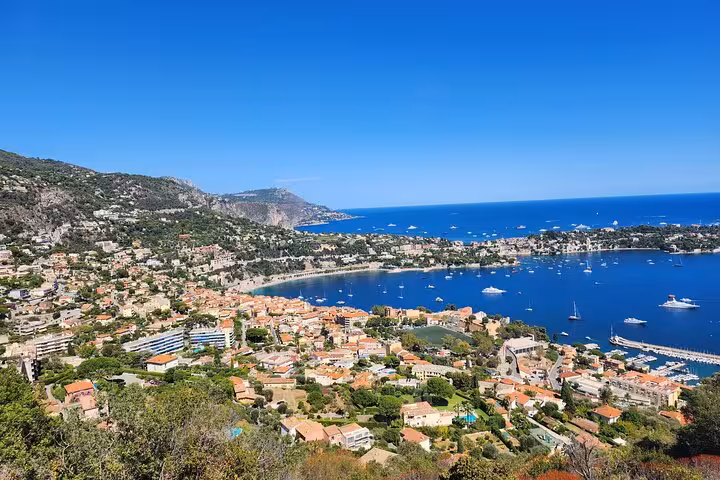 Scenic view of the French Riviera coastline with vibrant blue waters and charming hillside villages under a sunny sky.
