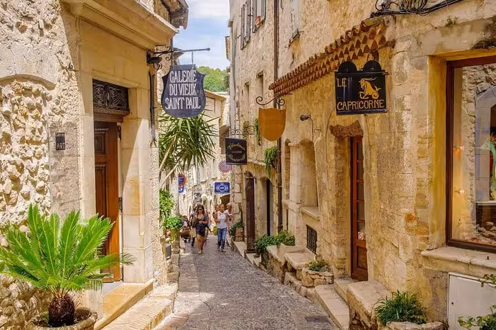 Charming cobblestone street in Saint-Paul-de-Vence with quaint shops on The Best of The French Riviera Tour.