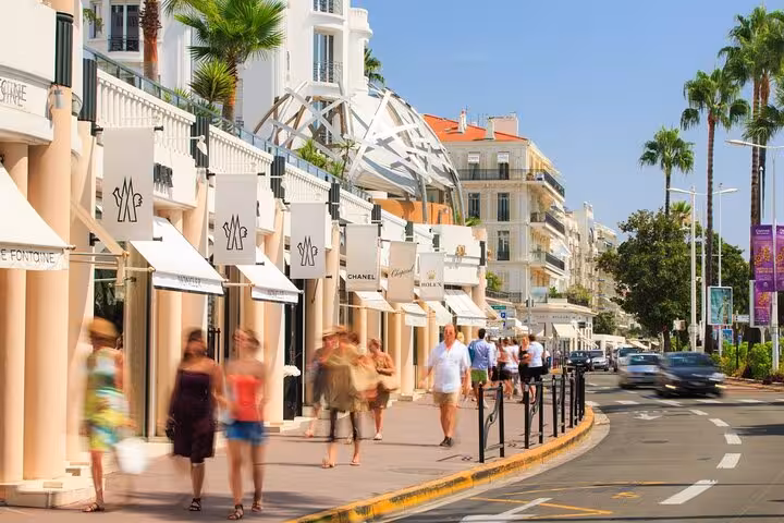 Luxury boutiques line a bustling street in the French Riviera, perfect for a shopping tour.