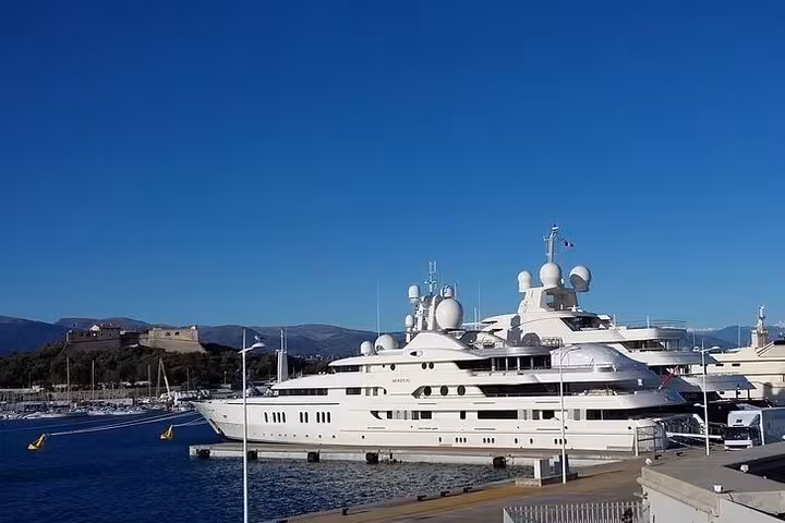Luxurious yachts docked at a marina in the French Riviera under a clear blue sky, showcasing opulence and elegance.