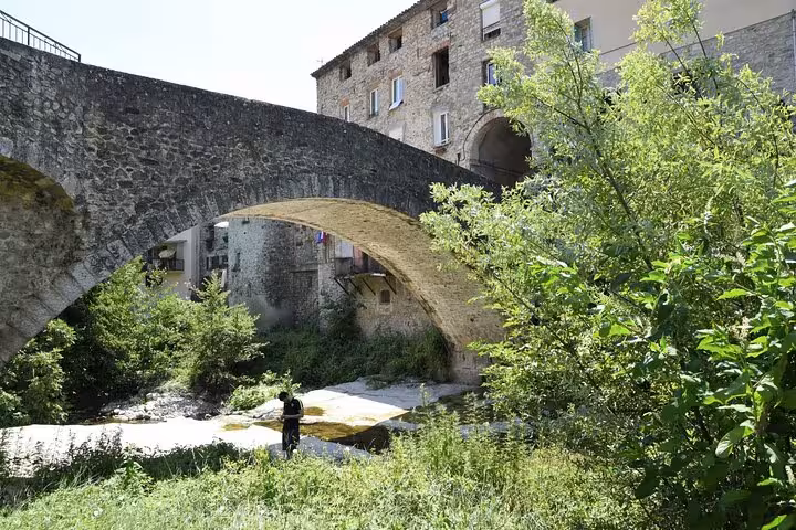 Ancient stone bridge and lush greenery in a quaint village setting on the French Riviera private tour.