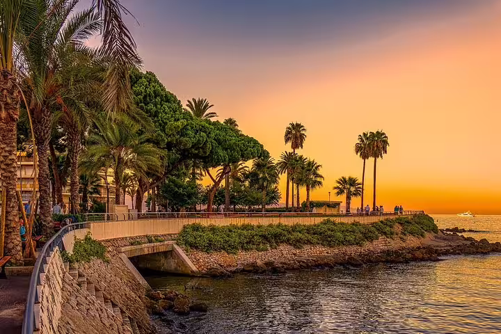 Sunset promenade with palms on the French Riviera, Cote d’Azur coastal walk near Cannes waterfront