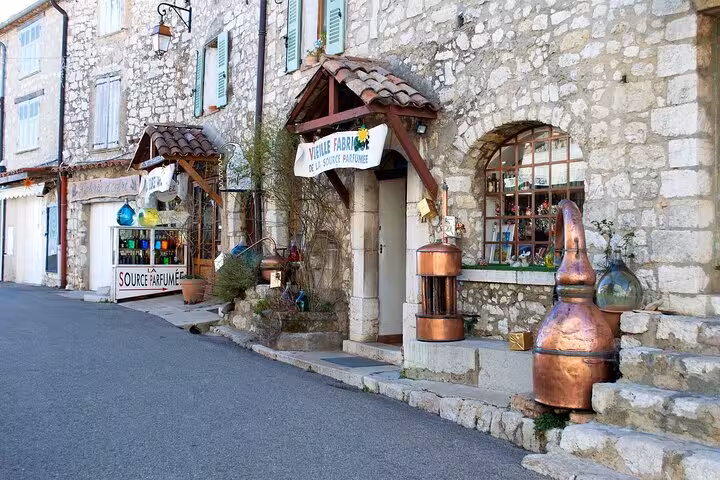 Charming stone street in a French Riviera village featuring quaint shops and rustic decor.