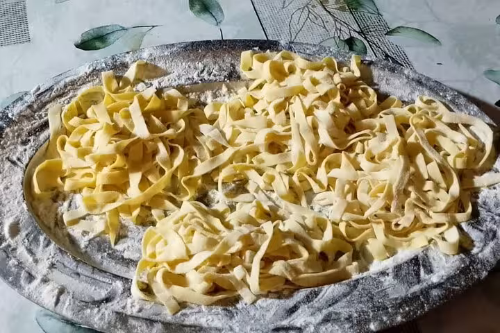 Fresh homemade pasta on a floured tray, ready to be cooked in a private cooking class in Rome.