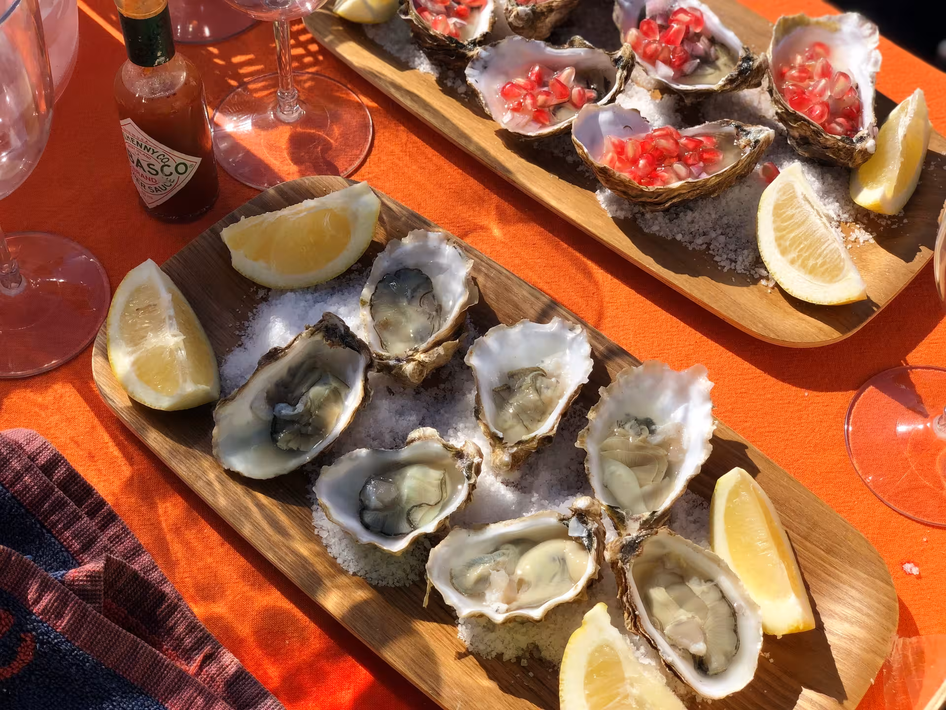 Fresh local oysters on ice with lemon wedges and hot sauce, served during a coastal oyster tasting experience