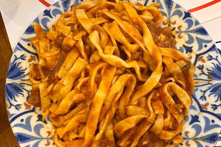 Plate of freshly made pasta with rich tomato sauce during a private cooking class in Rome, showcasing authentic Italian cuisine.