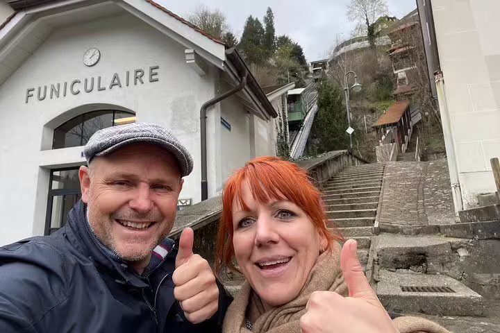 Couple at Fribourg Funiculaire station, thumbs up on a self-guided scavenger hunt walking tour with city sights