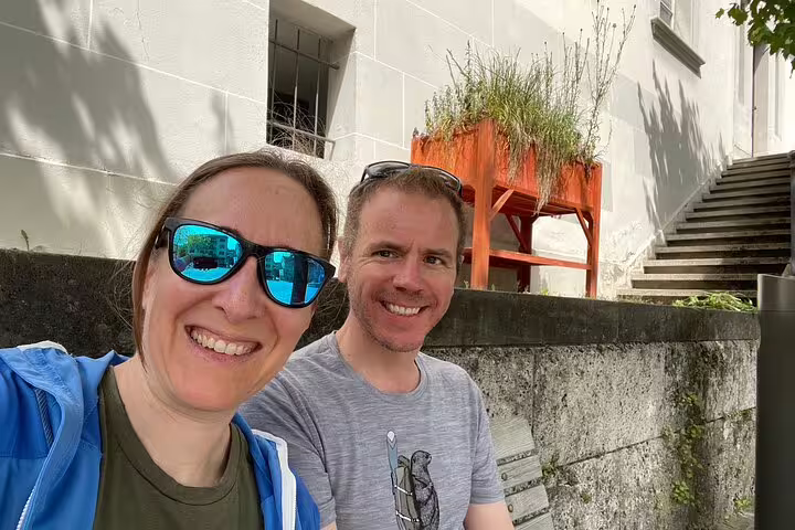 Couple taking a break on Fribourg self-guided scavenger hunt tour, near old town steps and scenic city sights