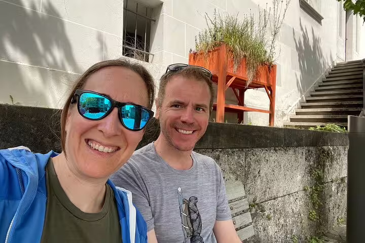 Couple selfie during a Fribourg scavenger hunt and sights self-guided tour, relaxing by old town steps