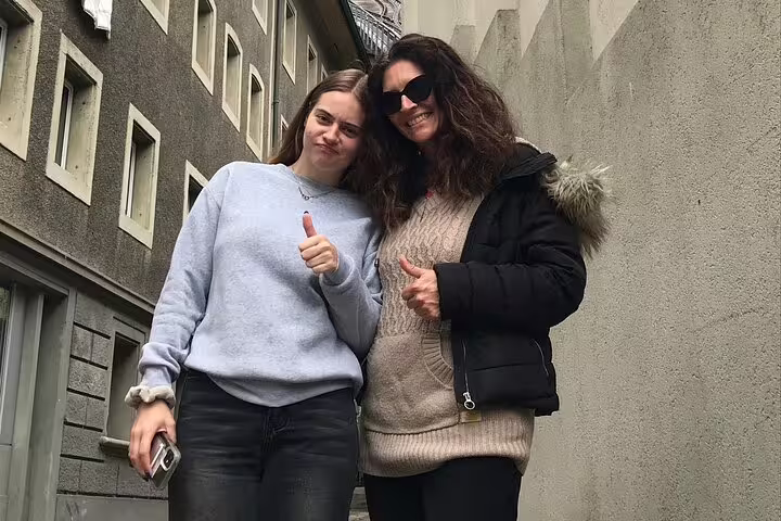 Two travelers giving thumbs up in a Fribourg alley during a self-guided scavenger hunt and sights tour