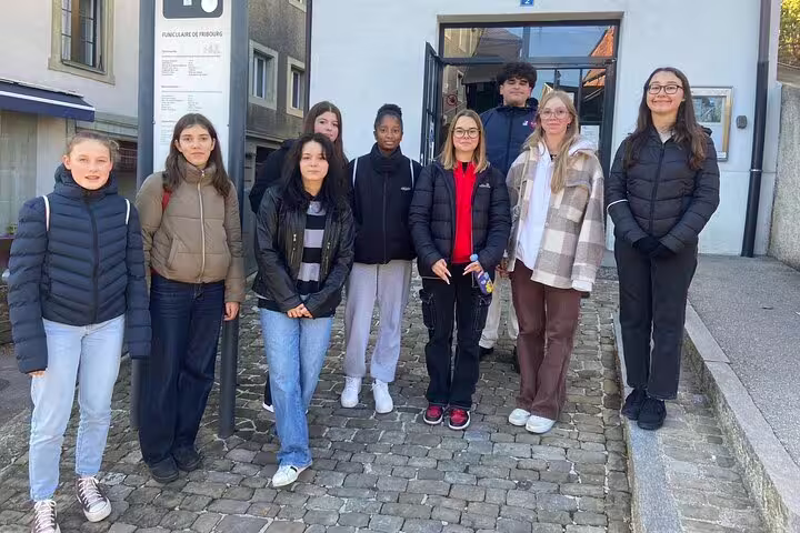 Group of travelers on a Fribourg scavenger hunt and sights self-guided walking tour in the old town