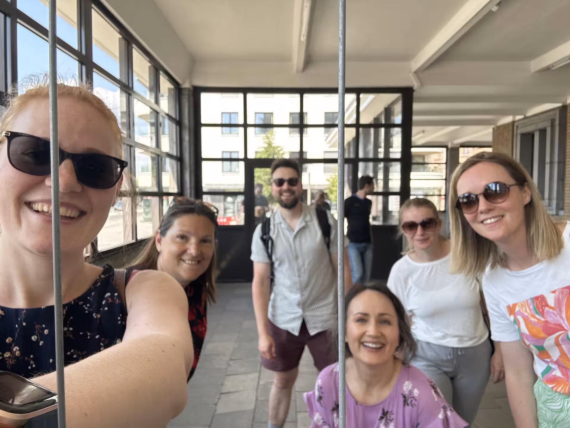 Friends laughing indoors on Antwerp e-scavenger hunt, smartphone city game to explore Antwerp at your own pace