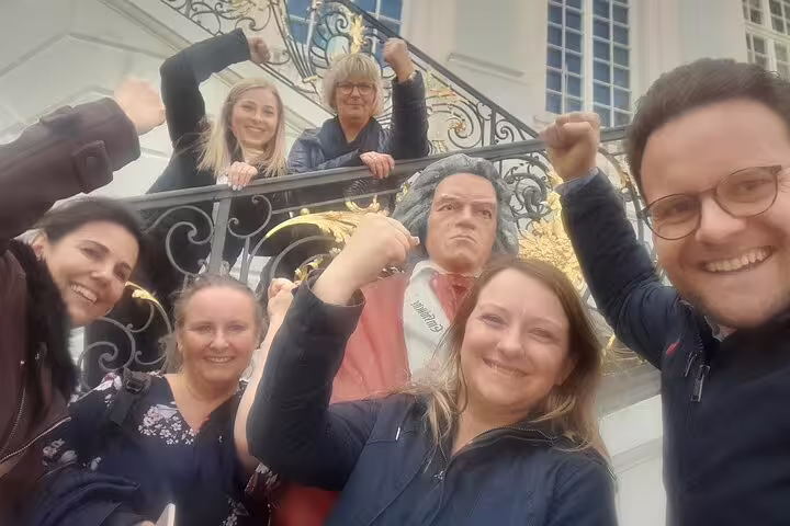 Friends pose by Beethoven statue during Bonn scavenger hunt, celebrating a fun self-guided sightseeing tour