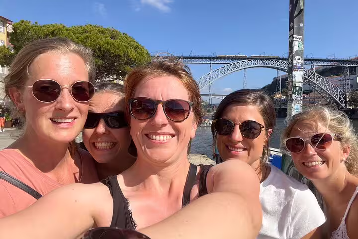 Friends selfie with Dom Luís I Bridge in Porto on a self-guided scavenger hunt and city sights tour
