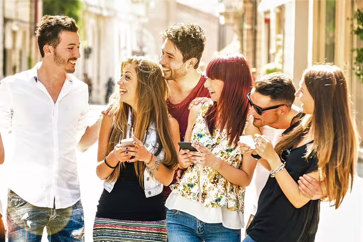 Friends using phones on sunny street during The Hague e-scavenger hunt, self-guided city exploration game