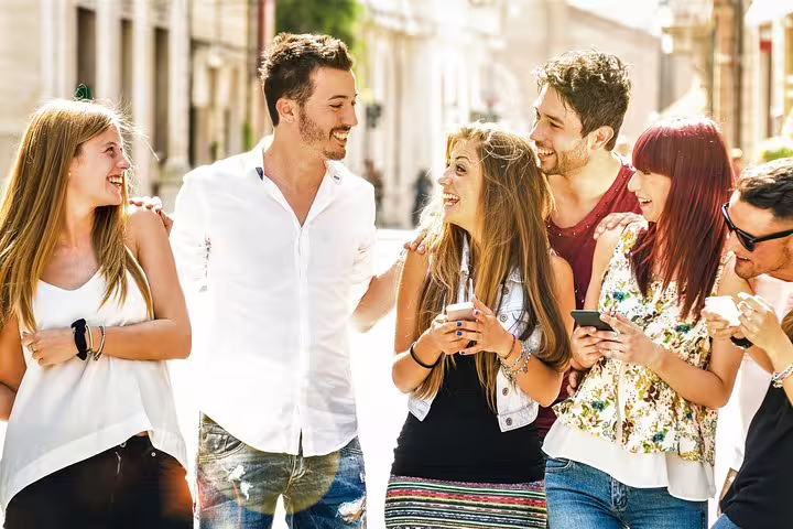 Friends exploring Bruges with phones on a self-guided e-scavenger hunt, fun walking tour in the old town