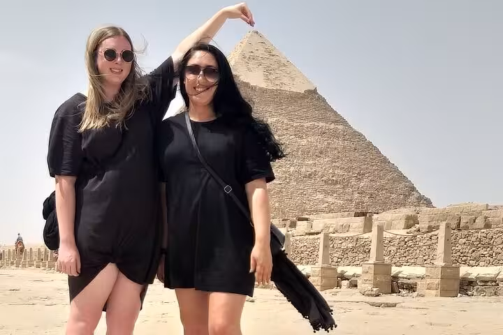Two friends posing playfully in front of the Great Pyramid of Giza during a private tour.