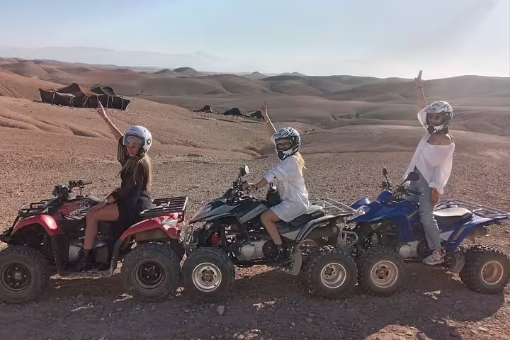 Friends posing on quad bikes in Agafay Desert near Marrakech, sunset ATV adventure before camel ride and dinner show