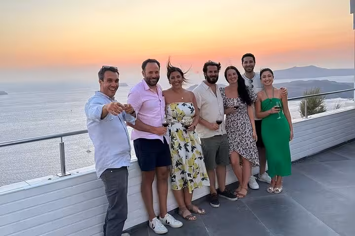 Friends posing at Santorini sunset viewpoint during wine tour, tasting local wines after visiting 2 wineries