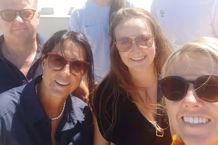 Friends taking a sunny selfie during an e-scavenger hunt in Bilbao, Spain, exploring city clues together