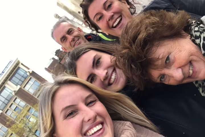 Smiling friends taking a selfie while playing a Bruges e-scavenger hunt, exploring landmarks at their own pace