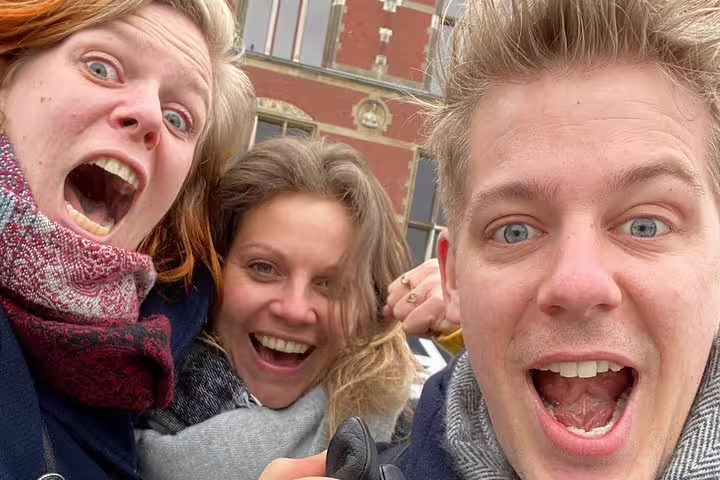 Friends taking a selfie in central Liège during a self-paced e-scavenger hunt, solving clues and exploring landmarks