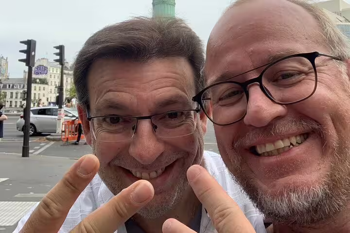 Smiling friends pose for a selfie while exploring Paris Marais District on a self-guided scavenger hunt tour