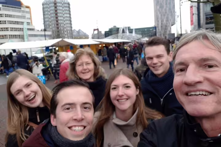 Friends taking a selfie at Rotterdam market, enjoying a fun self-paced e-scavenger hunt city exploration game