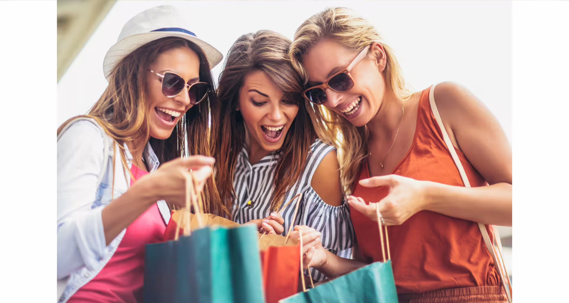 Group of happy friends with shopping bags enjoying a fashion spree at Designer Outlet La Reggia near Naples, Italy