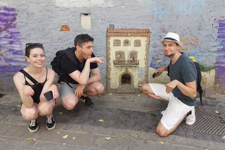 Friends solving a clue beside a tiny door in Valencia on the Iconic Sights Scavenger Hunt adventure
