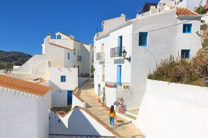Charming whitewashed buildings line a sunny street in Frigiliana, a must-see stop on the Málaga hiking tour.