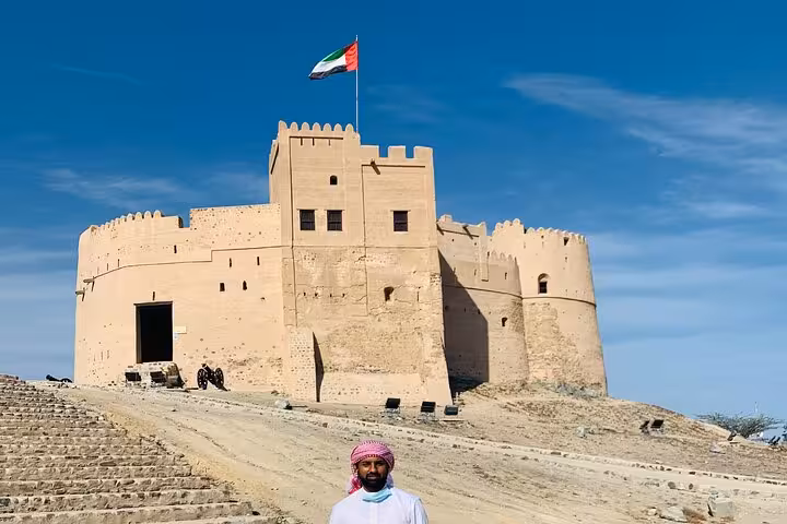 Historic Fujairah Fort museum with UAE flag, key stop on Fujairah City and Khorfakkan tour from Dubai
