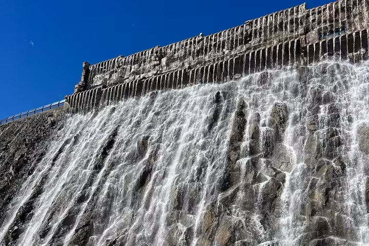 Water cascading over Fujairah dam in Hajar Mountains, scenic stop on Khorfakkan safari sightseeing tour