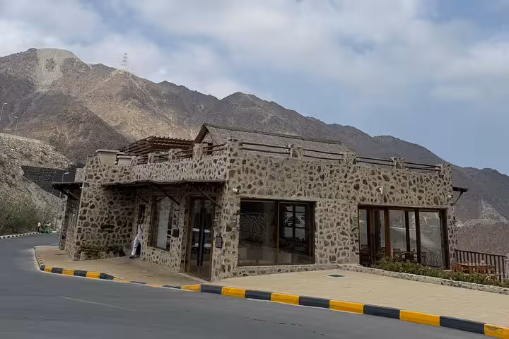 Stone-built heritage fort museum building on Fujairah City and Khorfakkan tour set against rugged mountains