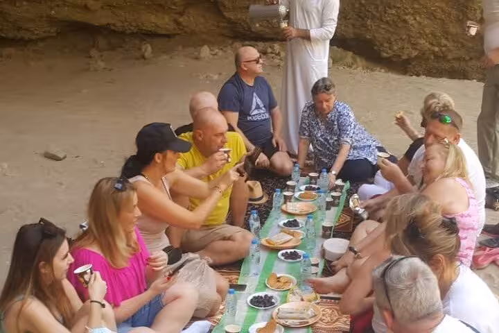 Group picnic in a rocky mountain cave during Fujairah Khorfakkan mountains safari sightseeing tour