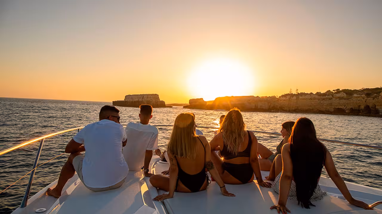 Group relaxing on yacht at sunset near Algarve cliffs on Full Day Cruise Diamond 12-hour ocean cruise experience