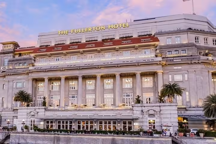 The Fullerton Hotel Singapore lit up at dusk, showcasing its neoclassical architecture and heritage charm.
