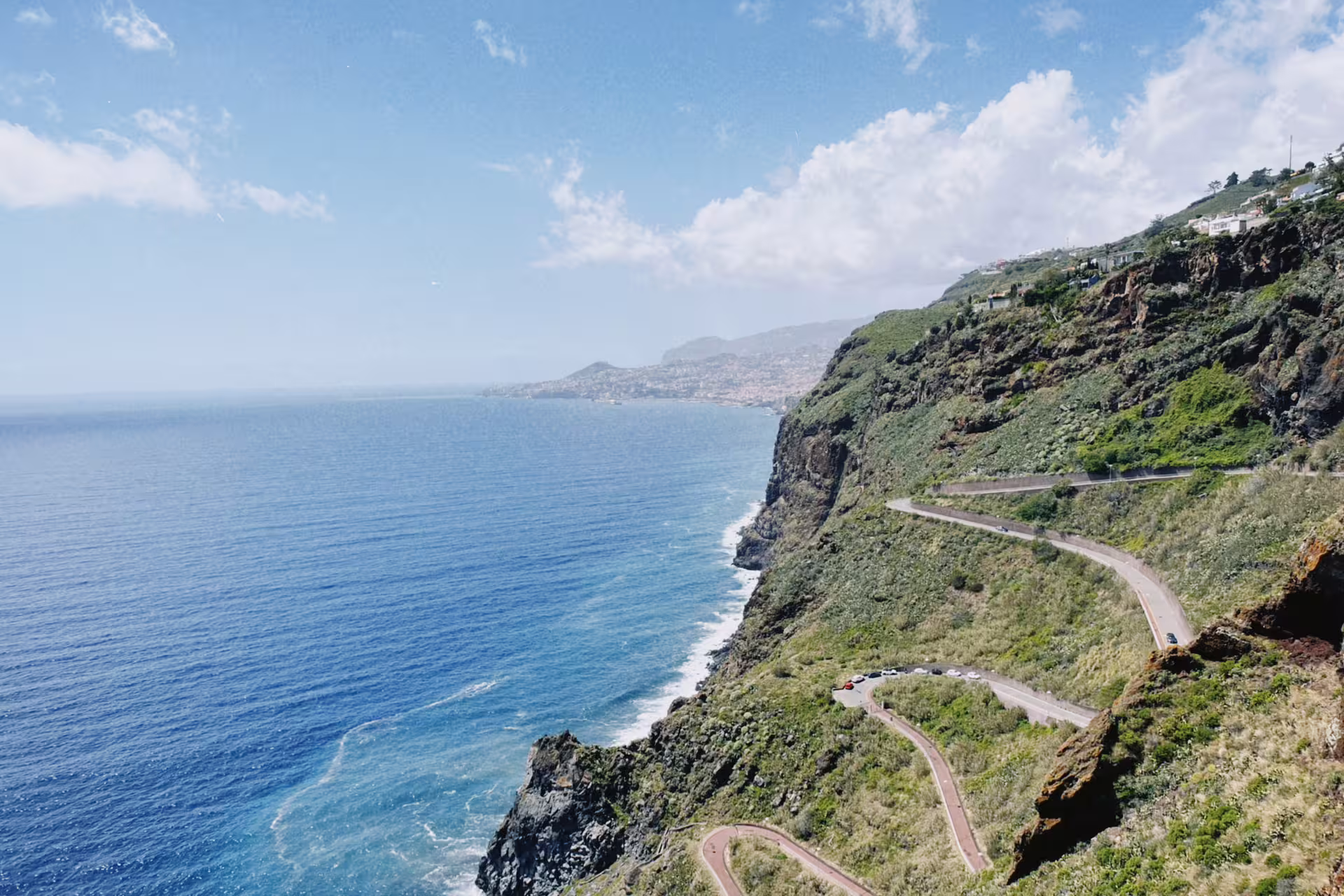 Scenic coastal road with winding paths along cliffs overlooking the ocean, ideal for e-bike tours from Funchal to Garajau.