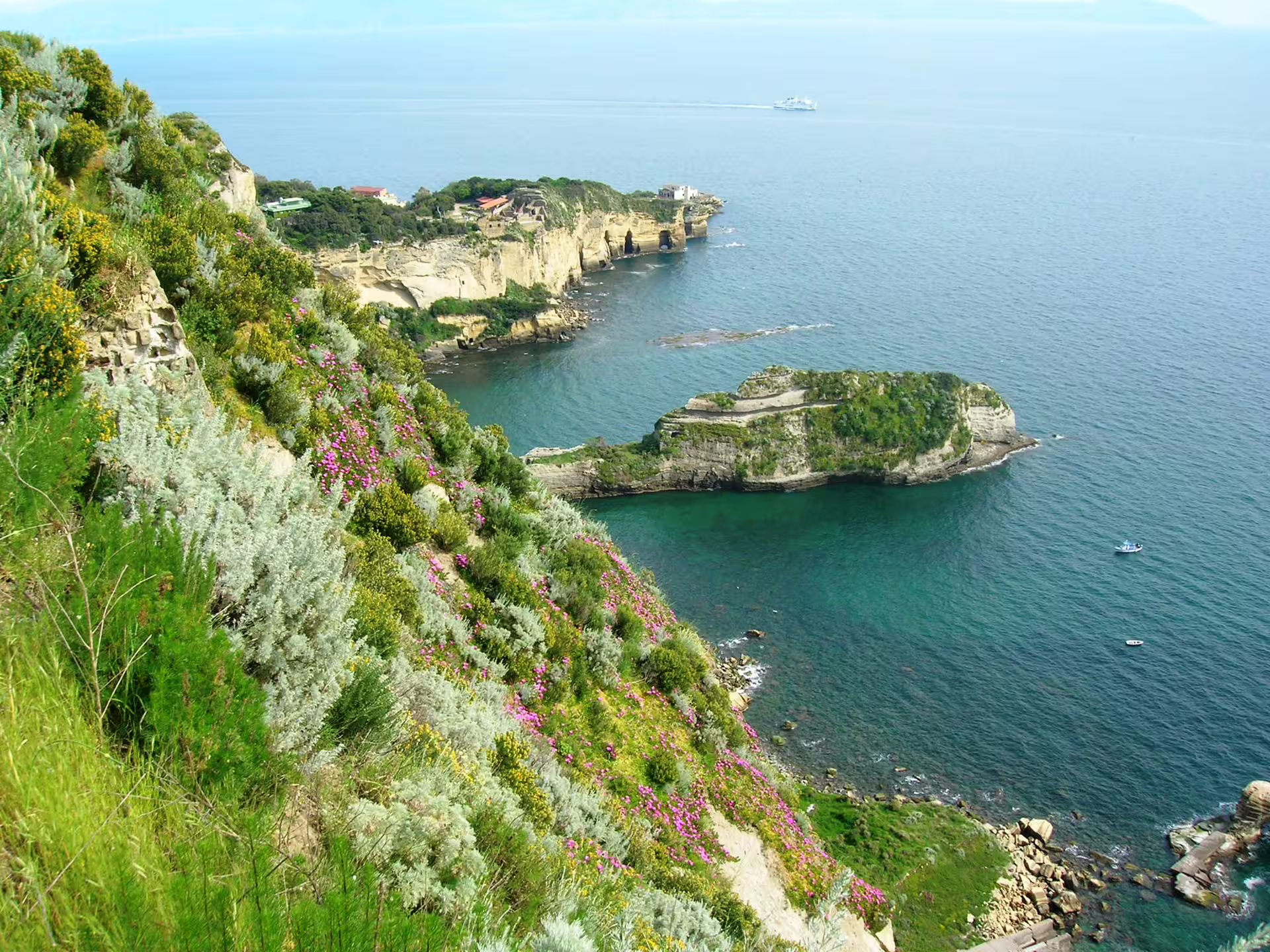 Verdant cliffs and islet of Gaiola in the protected marine park near Naples, viewed from a scenic Gulf of Naples boat excursion