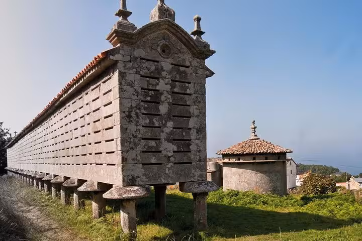 Traditional Galician horreo in a rural landscape, showcasing historical architecture on the Finisterre excursion.