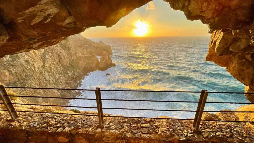 Stunning sunset view from Galleria Henry tunnel, overlooking the rugged Sardinian coastline and shimmering Mediterranean Sea.