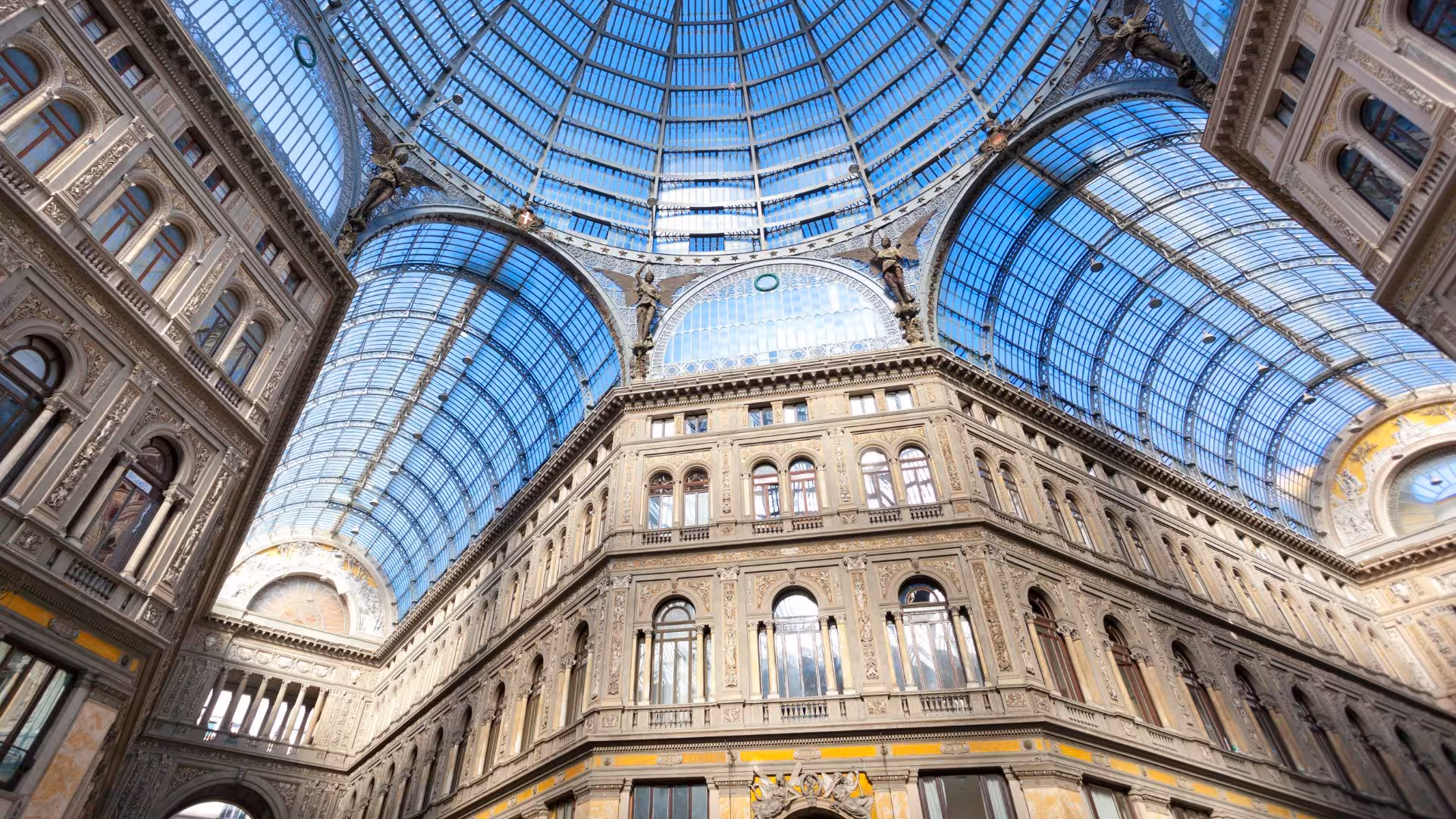 Stunning glass dome of Galleria Umberto I in Naples, highlighting intricate architecture and vibrant shopping atmosphere.