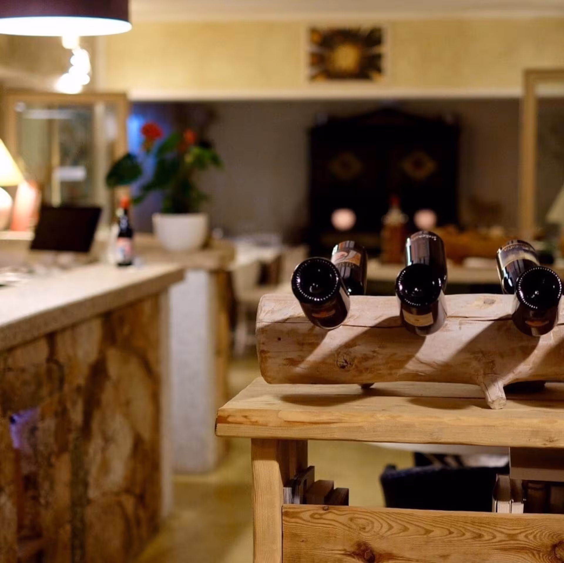 Rustic wine bottle display in cozy Gallura winery interior, Olbia, ideal for intimate wine tasting experiences.