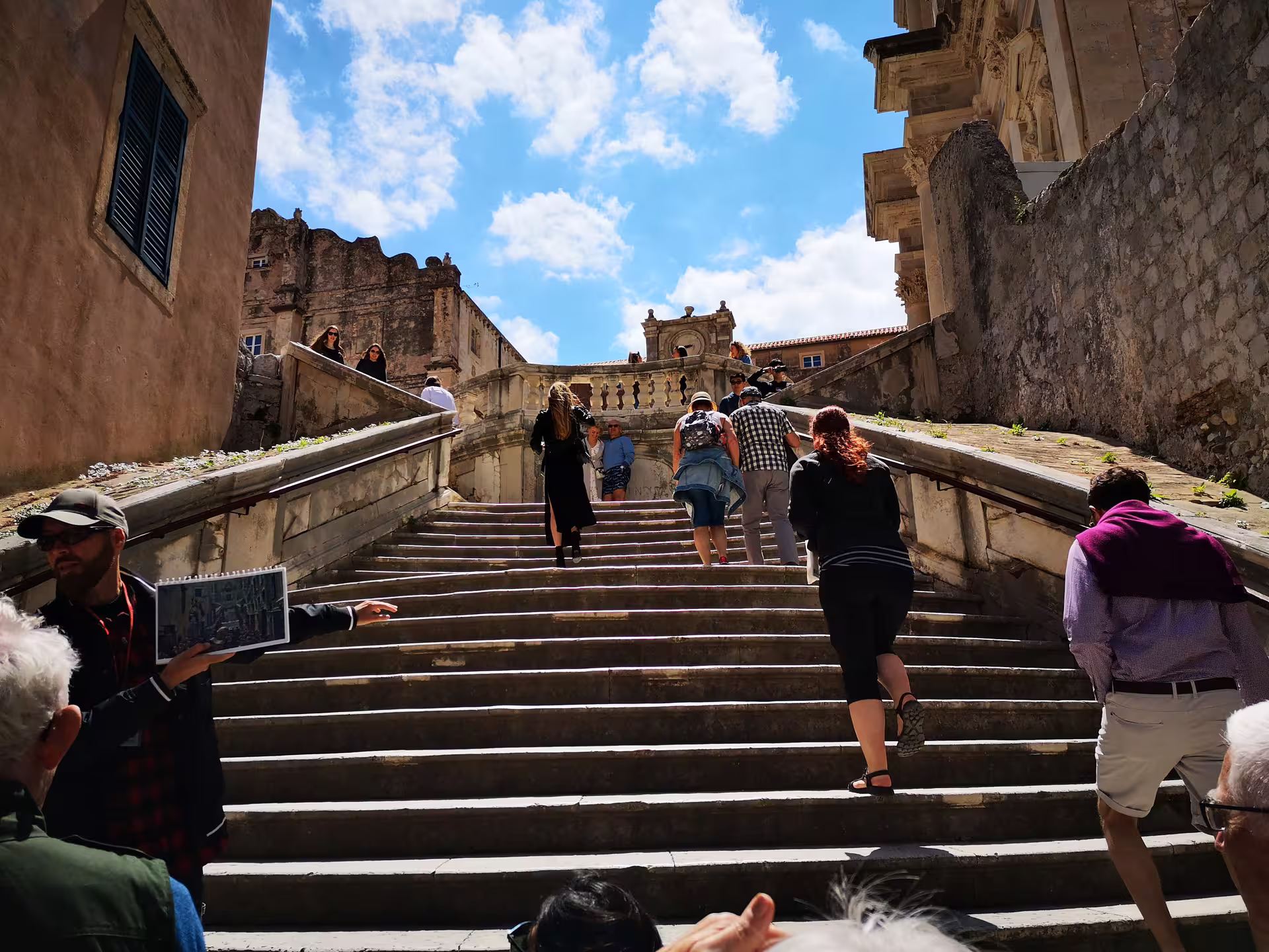 Tourists climb Jesuit Stairs on Dubrovnik Game of Thrones tour, guide points out iconic filming spot