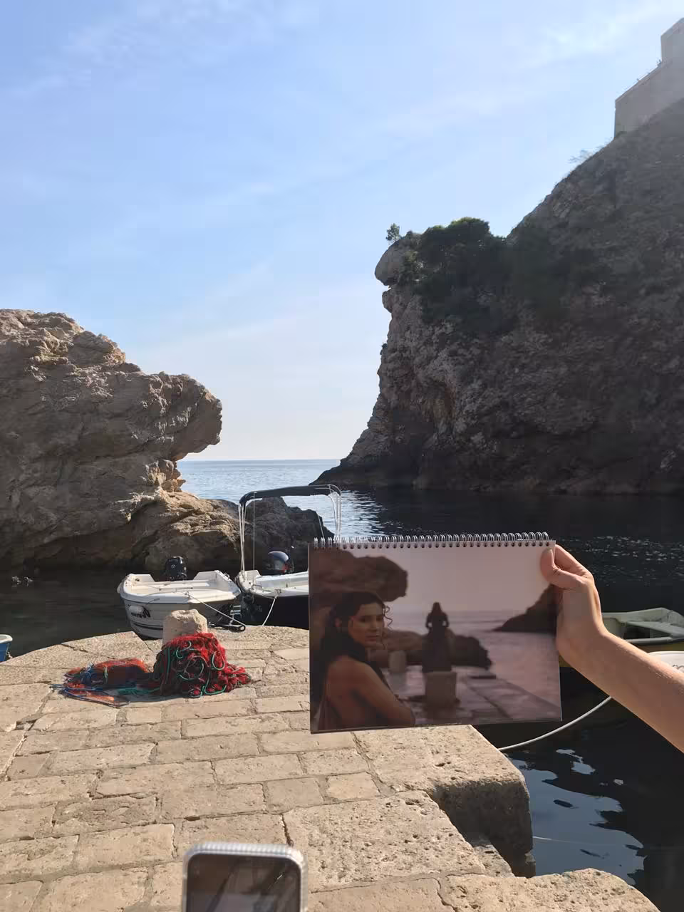 Game of Thrones filming spot at Dubrovnik’s West Harbor, shown on photo book during guided history walk tour