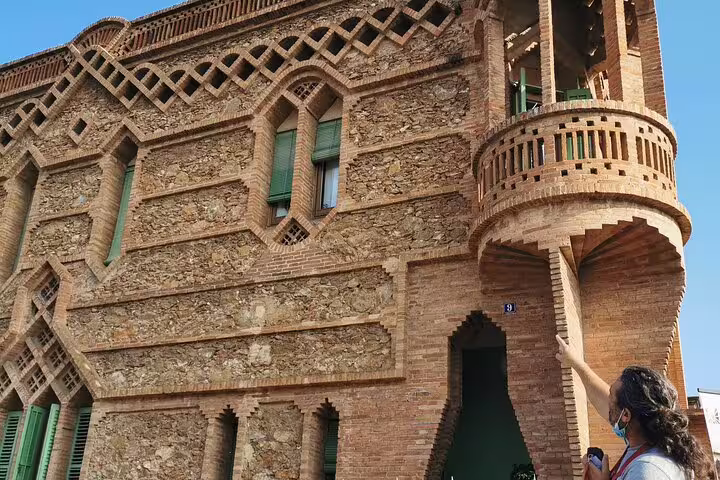 Tourist exploring the intricate brickwork of Colonia Güell on a skip-the-line private tour, showcasing Gaudí's architectural genius.